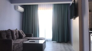 Una sala de estar moderna con un sofá, una mesa de centro y un televisor de pantalla plana montado en la pared.