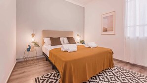 A neatly arranged hotel room with a bed, bedside tables, and a window with curtains. - Sweett | Rocafort Principal 1 (Barcelona)