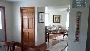 Una sala de estar con puerta de madera, un sofá, una mesita de centro y un tapete estampado.