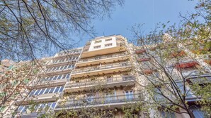 A multi-story building with balconies and a clear sky. - Sweett | Rocafort Entresuelo 2 (Barcelona)