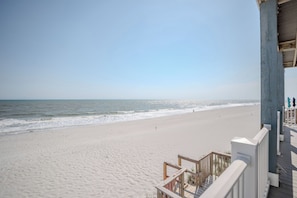 Ein Strand mit einer Holzterrasse und freiem Blick auf den Ozean.