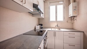 Una cocina moderna con horno empotrado, un lavamanos y un ventanal sobre la encimera.