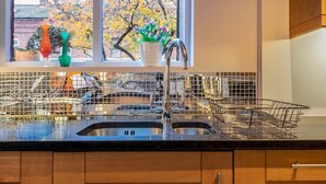 A kitchen with a large window, a sink, and a dish rack. - Colourful, Quirky Artist-Owned 3 Bed Next to Cafes - Pass the Keys (Belfast)