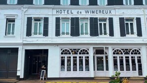 Un edificio de dos pisos con el letrero "HOTEL de WIMEREUX" en la parte superior.