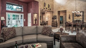 A spacious living room with a sectional sofa, a dining area, and a fireplace. - Cozy Timbers by Ruidoso Vacation Rentals (Ruidoso)