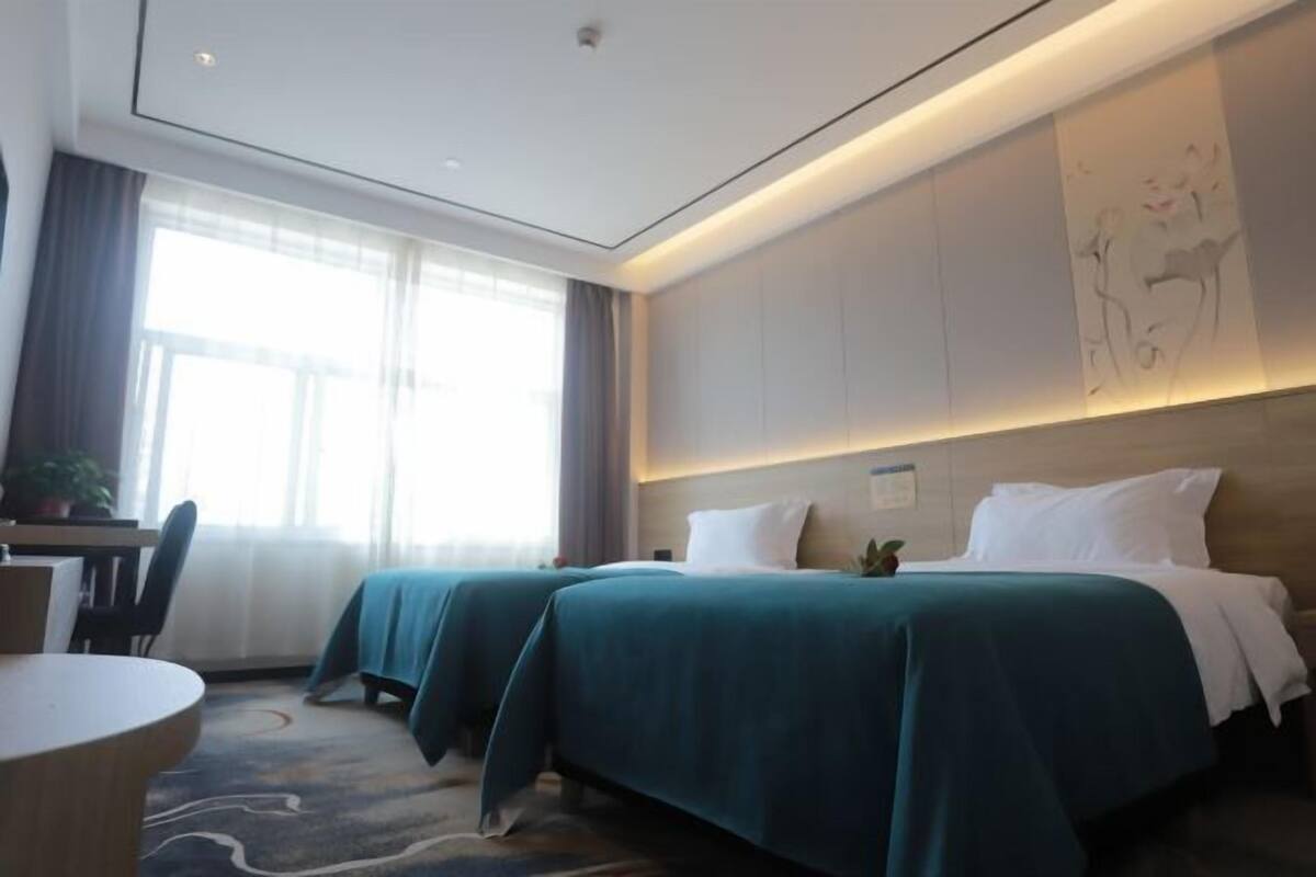 Habitación de hotel con dos camas, un escritorio y una silla.