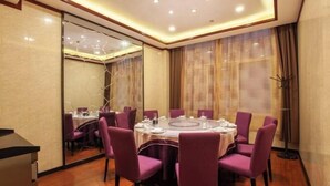 Une salle de conférence avec une table ronde, des chaises violettes et une cloison en verre.