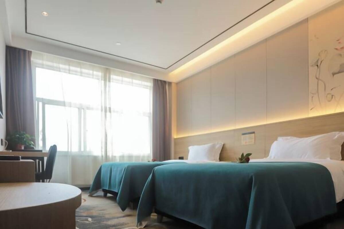 Habitación de hotel con dos camas, un escritorio y una silla.