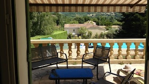 Ein Balkon mit Blick auf ein Haus und Grünflächen.