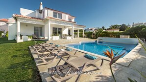 A modern villa with a swimming pool, outdoor seating, and a well-maintained lawn. - Silva (Albufeira)