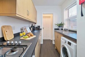 Enjoy cooking in this kitchen with a stove, cutting board, toaster, and microwave.