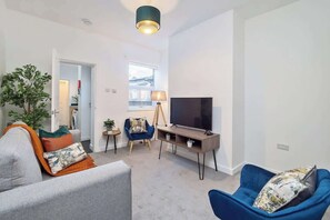 Relax in this stylish living room with a sofa, armchair, and flat-screen TV.