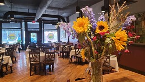 A restaurant interior with wooden tables, chairs, and a large floral arrangement on a table. - Masters rental - Historic federal in the heart of Edgefield county (Johnston)