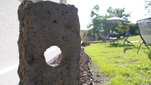 A concrete block with a hole, placed against a white wall. - Enter another world... (Châtel-Guyon)