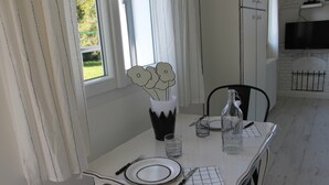 A dining table set with plates, cutlery, a vase with flowers, and a glass. - Enter another world... (Châtel-Guyon)