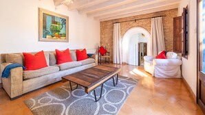 A living room with a sofa, armchairs, a coffee table, and a painting on the wall. - Casa Metge Vidal by Balearic Villas (Pollensa)