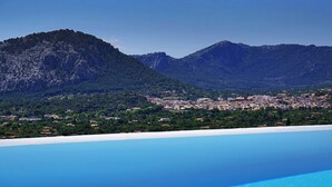 A coastal town with a view of mountains and a clear blue sky. - Casa Liebre by Balearic Villas (Pollensa)