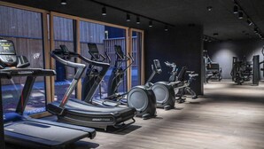 Een sportschool met loopbanden, elliptische trainers en gewichten.