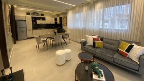 A modern living room with a sofa, coffee table, and dining area.