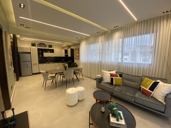 Una sala de estar moderna con sofá, mesa de centro y comedor.