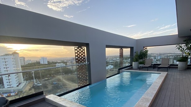A rooftop infinity pool with a view of the city skyline.