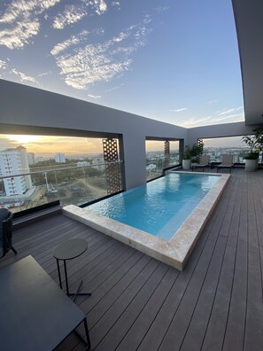 Piscina infinita en la azotea con vistas al horizonte de la ciudad.