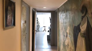 A hallway with a marble floor, a painting on the left, and a mural on the right. - Attico San Marco Top Floor Art 70 mq (Venice)