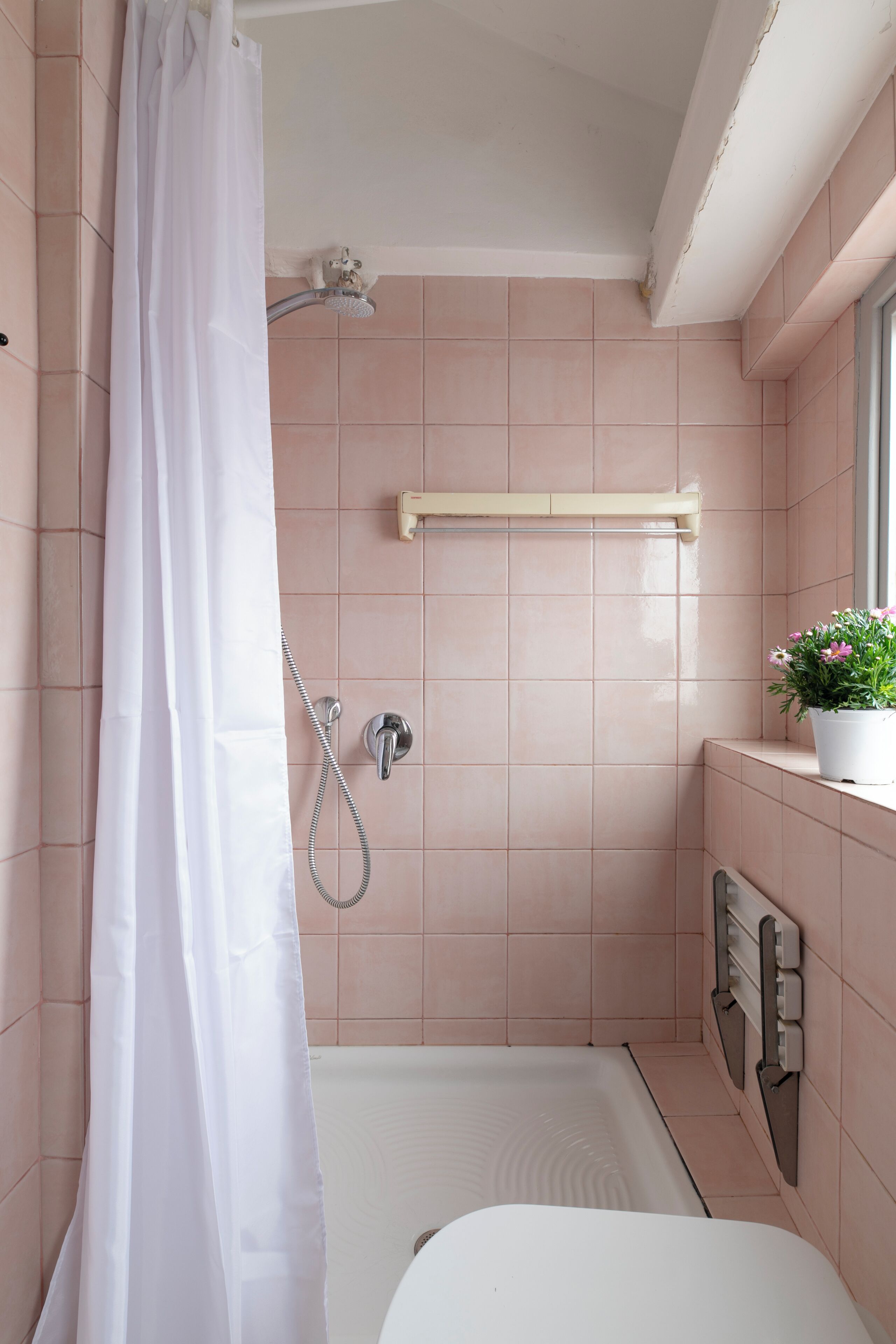 A bathroom with a shower, a toilet, and a sink.
