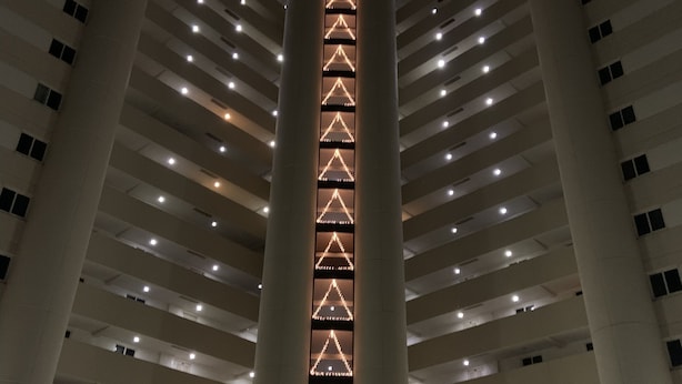 A multi-story parking garage with illuminated vertical light strips on the central column and a sign for "Atlantis 1000" at the bottom. - Direct Beachfront with pool (Ocean City)