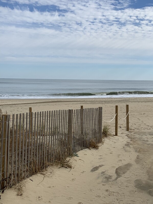 A beach with a wooden fence and a chain-link barrier. - Direct Beachfront with pool (Ocean City)