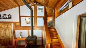Ein Holzinnenraum mit einer Treppe, einem Kamin und einer Holztür.