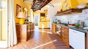 A kitchen with wooden cabinets, a tiled backsplash, and a variety of kitchen appliances.