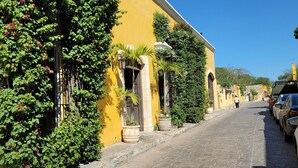 A narrow street lined with yellow buildings, some with greenery and flowers. - Beach Rental - Pet Friendly (chabihau)
