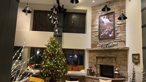 A spacious living area with a large Christmas tree, a fireplace, and modern lighting fixtures. - New Year's at Park City Marriott Mountainside -SKI IN SKI OUT (Park City)