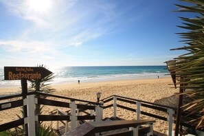Une plage avec un panneau indiquant « Rocha Palha Restaurante ».