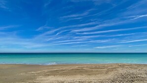 Una playa con cielos despejados y aguas tranquilas.