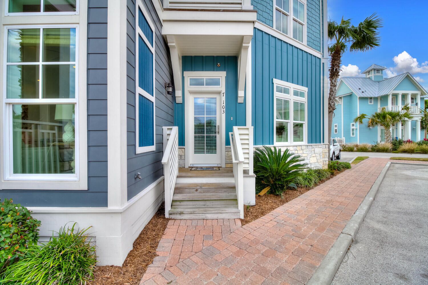 A two-story house with a front porch, a mailbox, and a driveway.