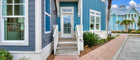A two-story house with a front porch, a mailbox, and a driveway.