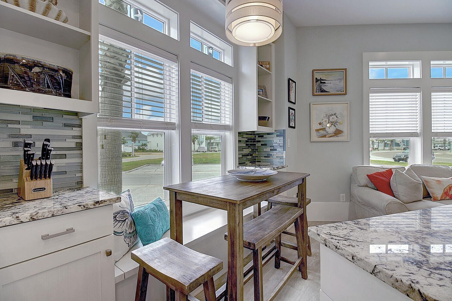 A kitchen with a wooden table, a bench, and a countertop with a knife block.