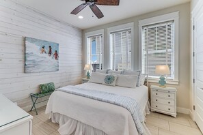 Relax in a serene bedroom with a large bed, nightstand, and abstract art.