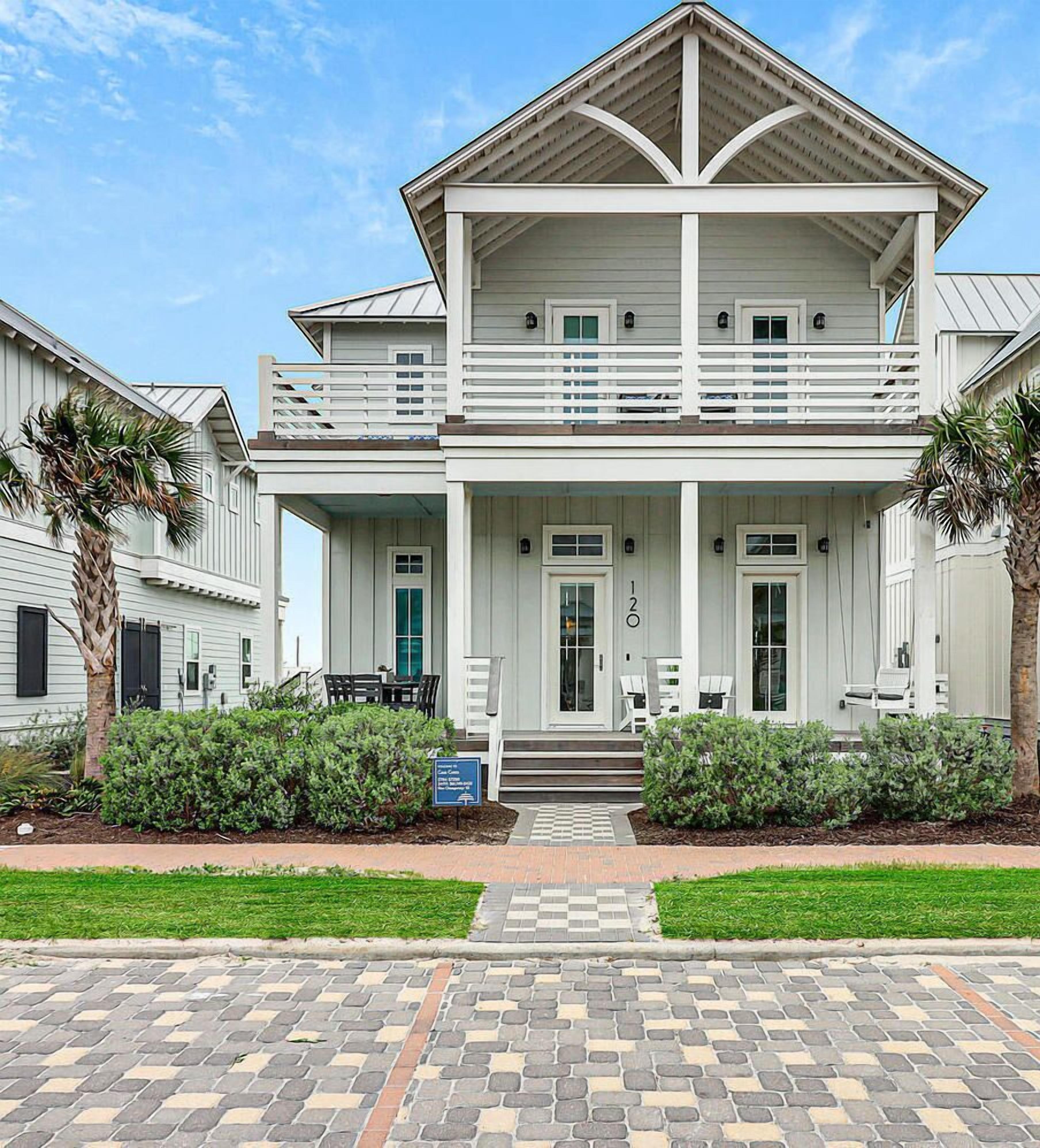 A two-story house with a balcony, a front porch, and a number '120' on the door.