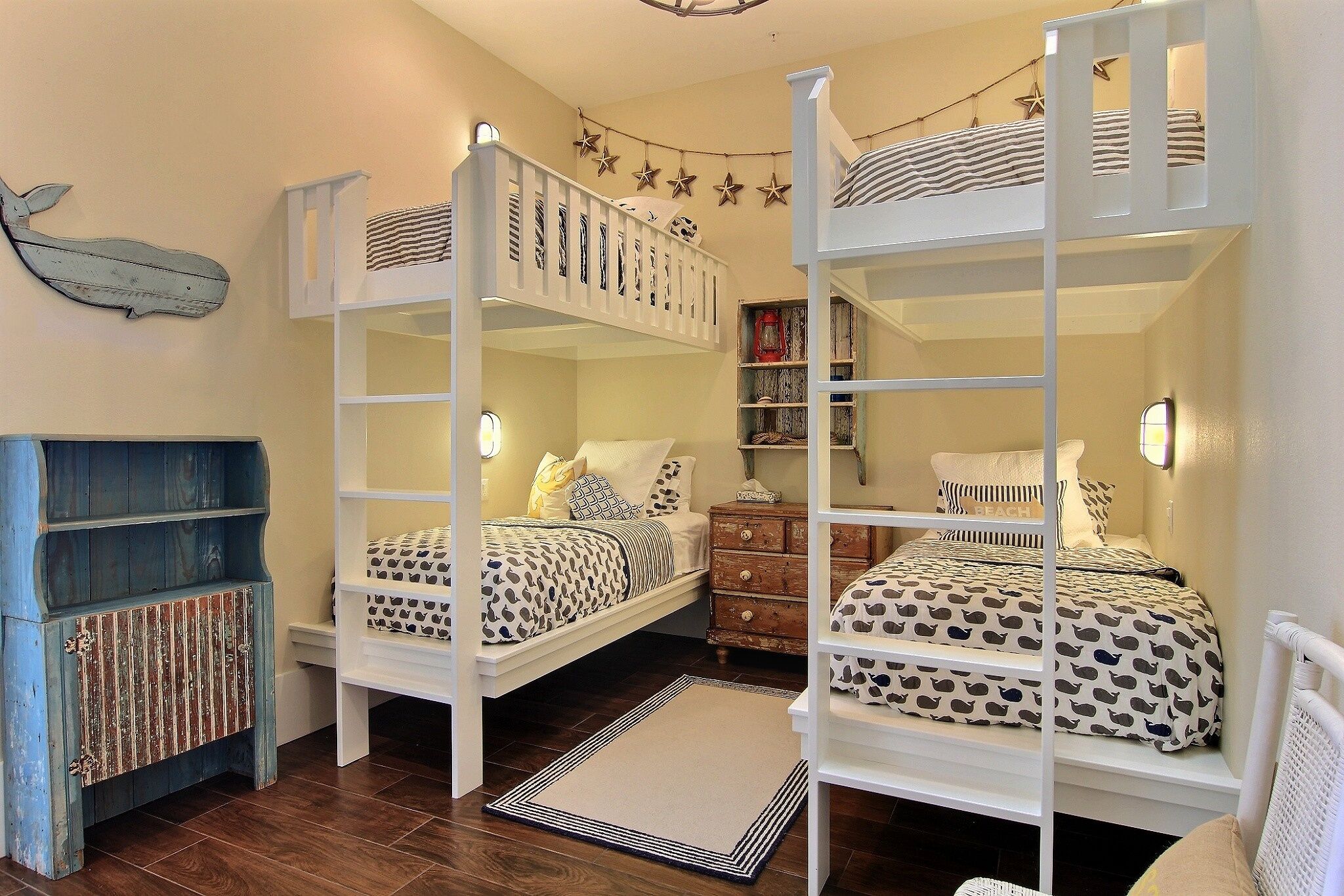 A room with bunk beds, a dresser, a bookshelf, and a star decoration on the wall.