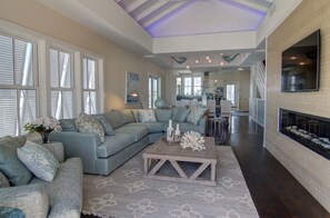 Relax in this stylish living area with a large sofa, coffee table, and fireplace.
