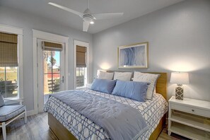 A bedroom with a bed, bedside table, and a ceiling fan. - Hip Nautic 113 WI (Port Aransas)
