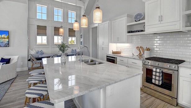 A spacious kitchen with a large island, white cabinetry, and a built-in oven. - Hip Nautic 113 WI (Port Aransas)