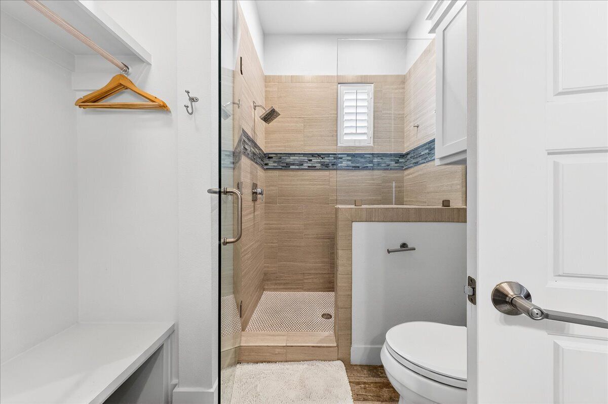 A bathroom with a shower, toilet, and sink.
