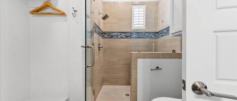 A bathroom with a shower, toilet, and sink.