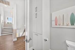 Ein modernes Badezimmer mit Toilette, Dusche und einer Treppe, die in einen anderen Raum führt.