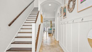 A clean, white interior with a wooden staircase leading to a living area. - Margaritaville 132 BE (Port Aransas)