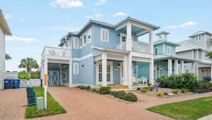 A two-story house with a porch, a garage, and a well-maintained lawn. - Margaritaville 132 BE (Port Aransas)